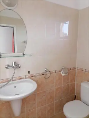 a bathroom with a sink and a toilet and a mirror at Ivet Guest Rooms - Obzor in Obzor