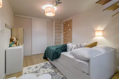 a bedroom with a white bed and a teddy bear at Black Sea Dolphin Apartment in Varna City