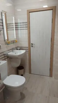 a bathroom with a toilet and a sink and a door at Sunrise City A1, Sarafovo in Burgas City