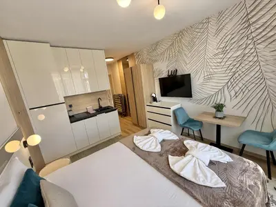 a bedroom with a bed and a desk and a television at Sorrento - Menada Apartments in Sveti Vlas