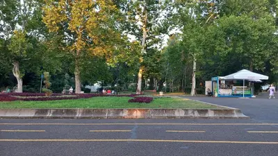 a parking lot with a park with trees and a tent at Апартамент Морски оазис in Burgas City