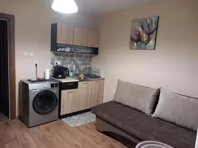 a living room with a couch and a washing machine at Апартамент Морски оазис in Burgas City
