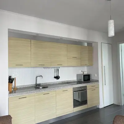 a kitchen with wooden cabinets and a microwave at YooBulgaria-Obzor SP apartments in Obzor