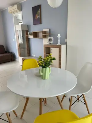a white table with yellow chairs in a living room at YooBulgaria-Obzor SP apartments in Obzor