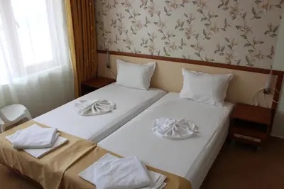two beds in a hotel room with towels on them at Kostovi Primorsko in Primorsko