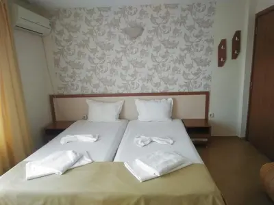 a bedroom with a bed with white towels on it at Kostovi Primorsko in Primorsko