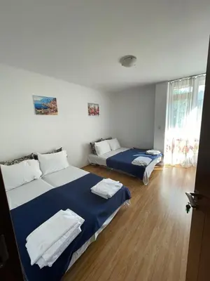 a room with two beds with blue and white sheets at Villa Flora SP apartments in Ravda