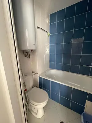 a blue tiled bathroom with a toilet and a tub at Villa Flora SP apartments in Ravda