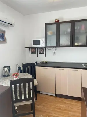 a kitchen with a counter and a table with a chair at Villa Flora SP apartments in Ravda