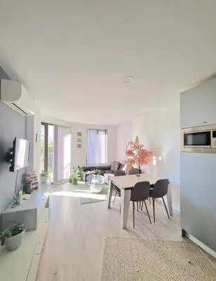 a white living room with a table and chairs at LOVE apartment in Burgas City