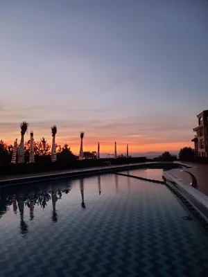 a swimming pool with a sunset in the background at LOVE apartment in Burgas City