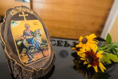 a small figurine of a cross on a table next to flowers at Effect Saint Mina in Sozopol