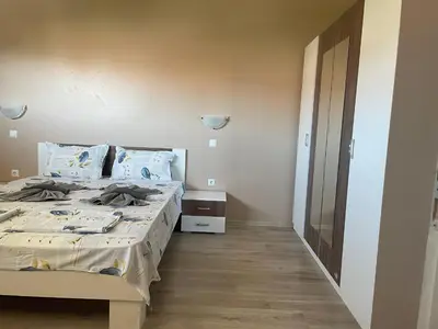 a bedroom with a large bed with a wooden floor at Cozy 1BD Apartment with a Lovely Sea View by Flat Mаnаger in Sveti Vlas