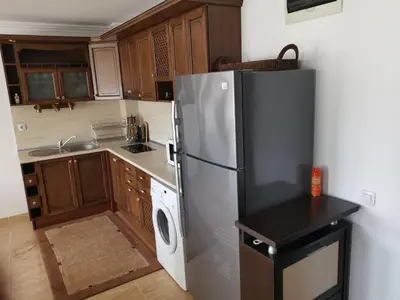 a kitchen with a stainless steel refrigerator and wooden cabinets at Sveti Vlas Kambani Bells 3 Ap 7a in Sveti Vlas