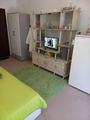 a room with a tv on a cabinet and a refrigerator at Венета 1 in Sozopol