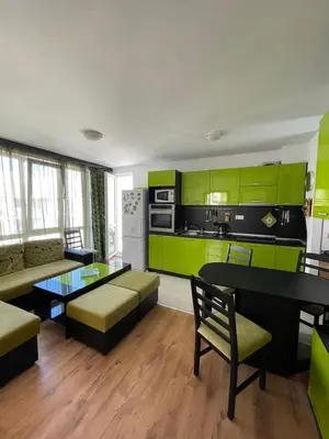 a living room with green cabinets and a kitchen at Atlantik-Byala SP apartments in Byala