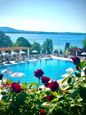 a swimming pool with chairs and umbrellas and the water at AJ Apartment 1 with Pool view, Santa Marina Holiday Village, Sozopol in Sozopol
