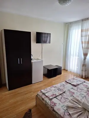 a bedroom with a bed and a flat screen tv at Къща за гости Симеонови in Sozopol
