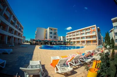 a group of lounge chairs and a swimming pool at 1-bedroom Apartment in a Resort with 6 Pools, Top Floor, Stunning Sunset View in Sunny Beach