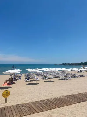 a beach with chairs and umbrellas and the ocean at Perla Del Mar Studio PANORAMA First line in Lozenets