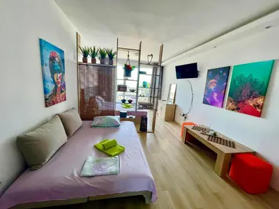 a living room with a couch and a table at Perla Del Mar Studio PANORAMA First line in Lozenets