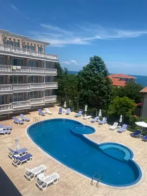 a hotel with a large swimming pool and lounge chairs at Perla Del Mar Studio PANORAMA First line in Lozenets