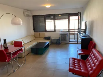a living room with a couch and red chairs at The modern apartment in the ancient city in Sozopol