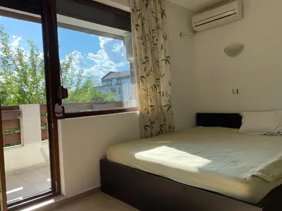 a bedroom with a bed and a large window at The modern apartment in the ancient city in Sozopol