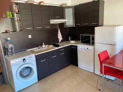a kitchen with a washing machine and a washer at The modern apartment in the ancient city in Sozopol