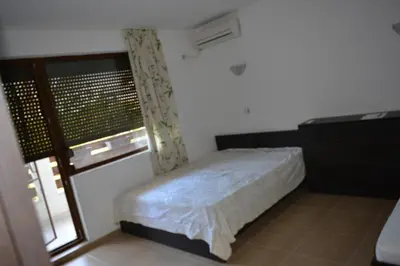 a small bedroom with a bed and a window at The modern apartment in the ancient city in Sozopol