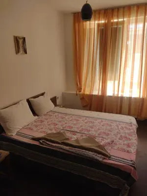 a bed in a room with a window and a bedspread at Хаджи Иванов in Varna City