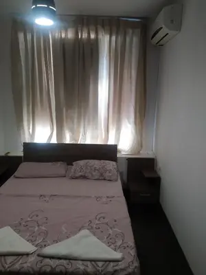 a bedroom with a bed and a window with curtains at Хаджи Иванов in Varna City