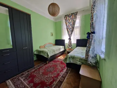 a room with two beds and a window at Етаж от къща с двор in Burgas City