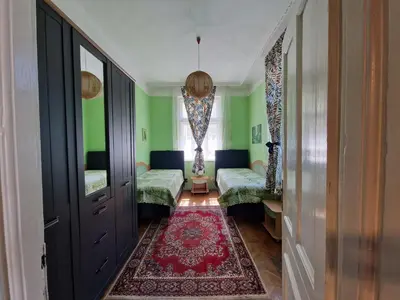 a room with green walls and a red rug at Етаж от къща с двор in Burgas City