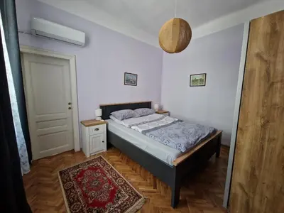 a bedroom with a bed and a door and a rug at Етаж от къща с двор in Burgas City