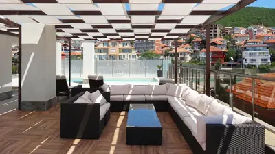 a balcony with a white couch and a pool at Premium Apartment Villa Aristo in Sveti Vlas