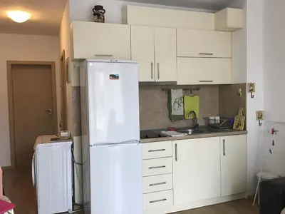 a kitchen with a white refrigerator and white cabinets at Casa del Mar Apartment in Obzor