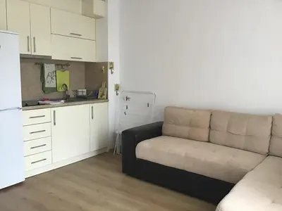 a living room with a couch and a kitchen at Casa del Mar Apartment in Obzor
