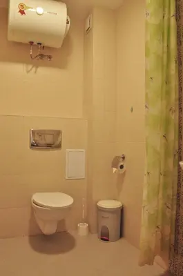 a bathroom with a toilet and a trash can at Casa del Mar Apartment in Obzor