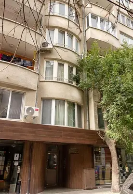 a building with a tree in front of it at The Blue Apartment - 1BD with a Cozy Balcony by Flat Mаnager in Varna City