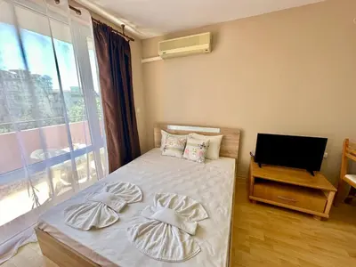 a bedroom with a bed with pillows and a television at Privilege Fort Beach - Menada Apartments in Elenite