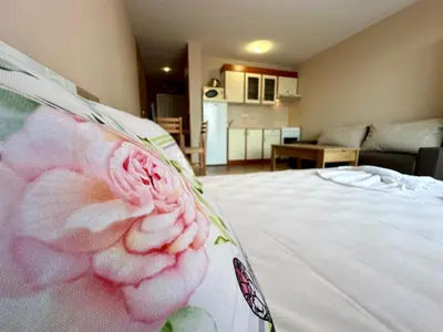 a bedroom with a white bed with a flower on it at Privilege Fort Beach - Menada Apartments in Elenite
