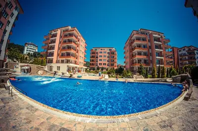 a large blue swimming pool with two tall buildings at Privilege Fort Beach - Menada Apartments in Elenite