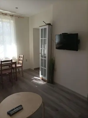 a living room with a table and a tv on a wall at Apartment Starfish in Varna City
