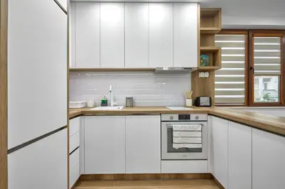 a white kitchen with white cabinets and a sink at Weiss Estate by EstateAutomata in Burgas City