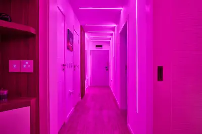a corridor with pink lights in a hallway at Miami Vibe by EstateAutomata in Burgas City