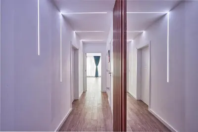 a long hallway with white walls and a mirror at Miami Vibe by EstateAutomata in Burgas City