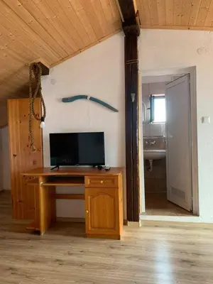 a room with a desk with a television and a bathroom at Sozopol Old Town - Guest House Fenix in Sozopol