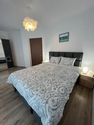 a bedroom with a bed with a blue and white bedspread at Azzurro Premium Apartment on Bulevard Bogoridi in Burgas City