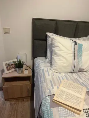 a bedroom with a bed with a book on it at Azzurro Premium Apartment on Bulevard Bogoridi in Burgas City